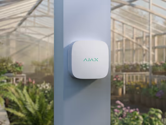 AJAX Hub blanc installé en extérieur — serre agricole, environnement humide